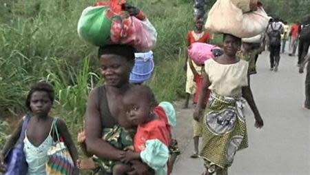 People walk as they leave Begoua for capital Bangui, 17 km (10 miles) away, in this still image taken from video, March 23, 2013. REUTERS/Reuters TV