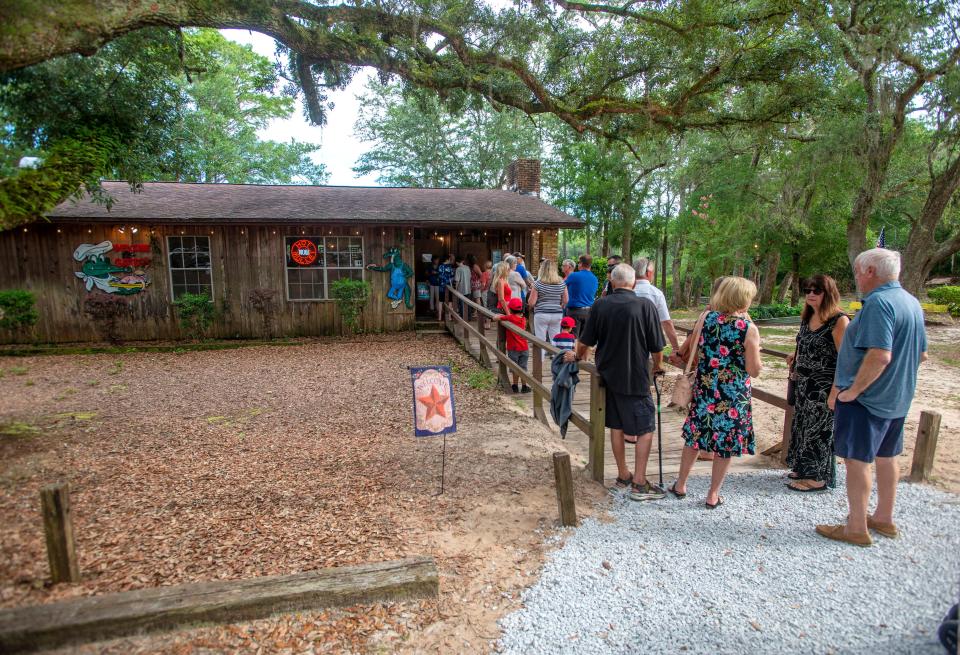 Customers wait in line to get into Gator's Seafood in Milton, Saturday, July 17, 2021.