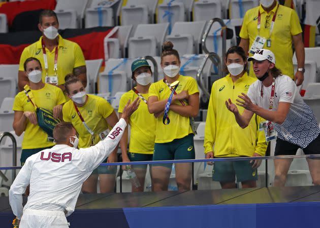 Caeleb Dressel throws his gold medal to Brooks Curry. (Photo: Tom Pennington via Getty Images)