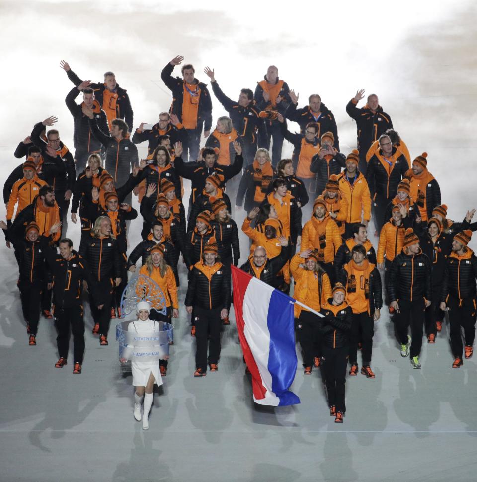 Jorien ter Mors of Netherlands holds her national flag and enters the arena with teammates during the opening ceremony of the 2014 Winter Olympics in Sochi, Russia, Friday, Feb. 7, 2014. (AP Photo/Charlie Riedel)