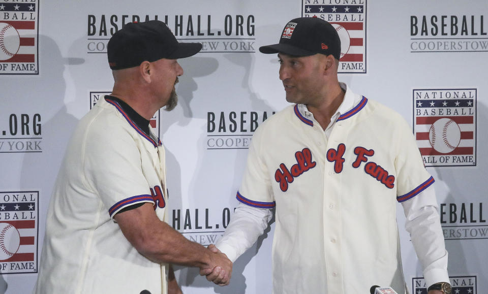 Colorado Rockies outfielder Larry Walker, left, and New York Yankees shortstop Derek Jeter shake hands after receiving their Baseball Hall of Fame jersey and cap, Wednesday Jan. 22, 2020, during a news conference in New York. (AP Photo/Bebeto Matthews)