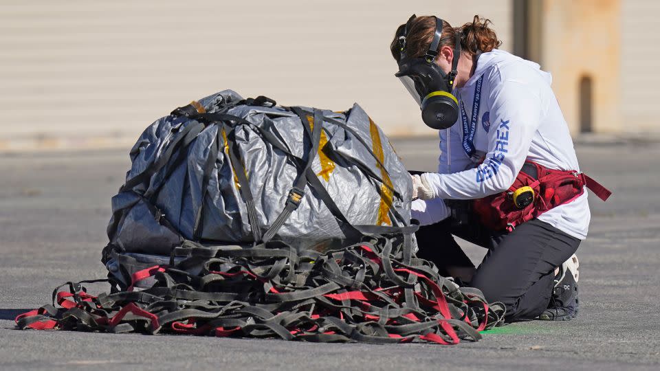 A recovery team member examined the capsule before it was taken to a temporary clean room at Dugway Proving Ground in Utah. - Rick Bowmer/AP