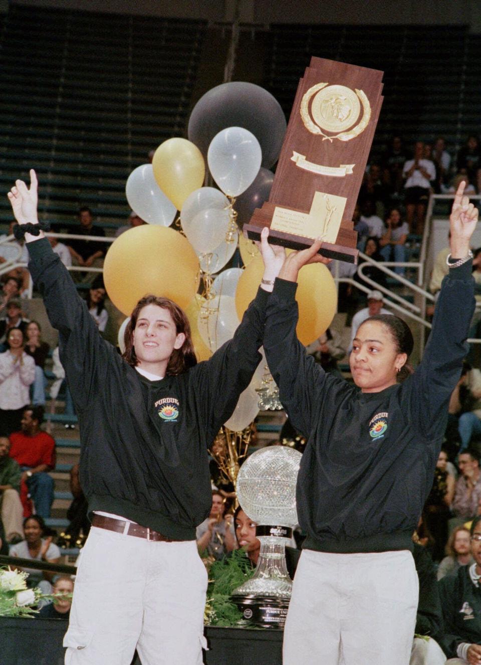 Purdue seniors Stephanie White-McCarty left and Ukari Figgs hoist the NCAA women's national basketball championship trophy aloft Wednesday March 31 1999 at a celebration held in the team's honor at Mackey Arena in West Lafayette Ind. (AP Photo/David Umberger)