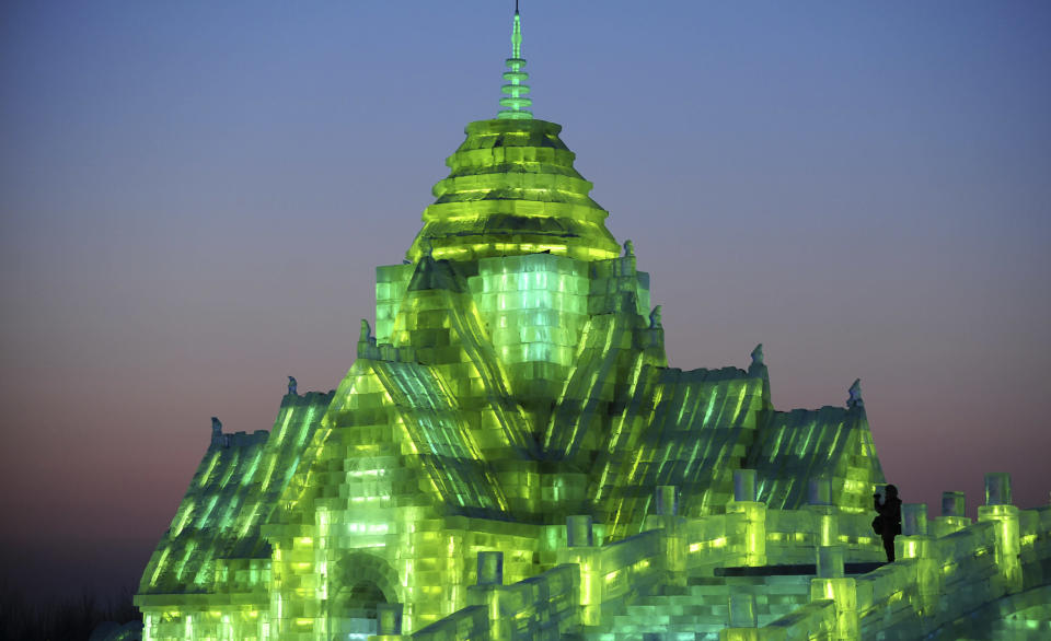 A tourist records video on ice sculptures during the lights testing period of the 13th Harbin Ice and Snow World in Harbin, Heilongjiang province December 25, 2011. The Harbin International Ice and Snow Festival will be officially launched on January 5, 2012. Picture taken December 25, 2011. REUTERS/Sheng Li (CHINA - Tags: ENVIRONMENT SOCIETY)