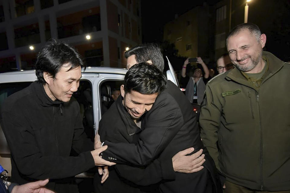 In this photo provided by Thailand's Foreign Ministry, two newly-freed Thai hostages hug Thai Foreign Minister Parnpree Bahiddha-Nukara, third form left, after arriving at the Shamir Medical Center in Israel, Tuesday, Nov. 28, 2023. Hamas freed several Thai nationals seized in the group's surprise attack on southern Israel the month before, releasing them alongside Israeli hostages under a cease-fire deal. (Thailand's Foreign Ministry via AP )