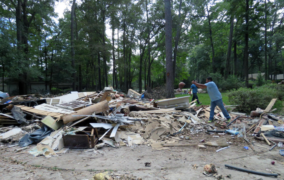 FILE - In this Sept. 26, 2017, file photo, workers continue clearing debris from the home of Houston resident Chris Slaughter, whose house in the suburb of Kingwood was flooded by 5 1/2 feet of water during Harvey's torrential rainfall. Although many Texas families are still struggling to recover from Hurricane Harvey a year after it caused widespread damage and flooding along the Gulf Coast and in and around Houston, daily life has mostly returned to normal in many of the hardest hit communities. (AP Photo/Juan Lozano, File)