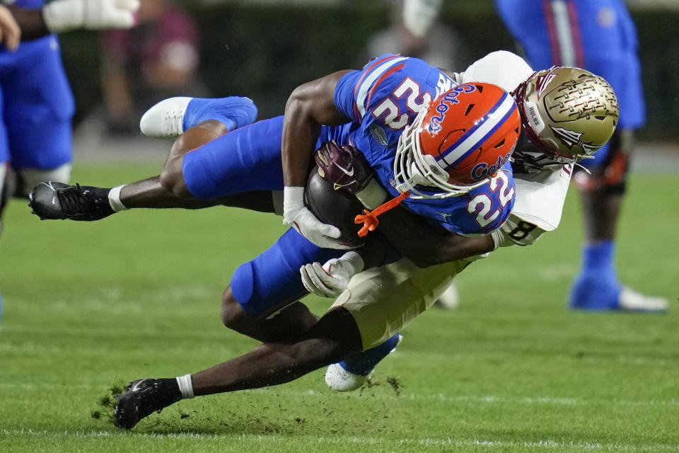 Florida wide receiver Kahleil Jackson (22) is stopped by Florida State defensive back Renardo Green, right, after a reception during the first half of an NCAA college football game Saturday, Nov. 25, 2023, in Gainesville, Fla. (AP Photo/John Raoux)