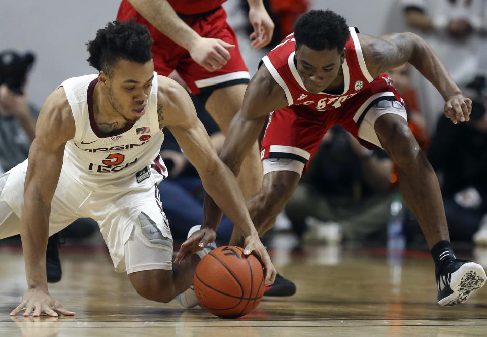 Virginia Tech's Wabissa Bede (3) and North Carolina State's Markell Johnson (11) battle for a loose ball in the first half of an NCAA college basketball game Saturday, Jan. 11, 2020, in Blacksburg, Va. (Matt Gentry/The Roanoke Times via AP)