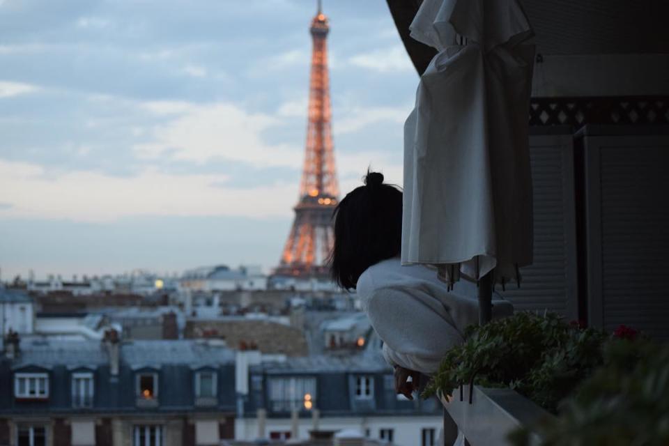 London-based travel blogger Candace Salters hanging over a balcony on Rue Miollisas in Paris, France. Salters, the founder of Candace Abroad moved from the US to London at age 18 and has since worked to encourage other women of color, specifically Black women to travel outside of the US more.