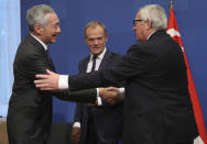 Singapore's Lee Hsien Loong, left, shakes hands with European Commission President Jean-Claude Juncker, right, and European Council President Donald Tusk, after signing an agreement of understanding during an EU-ASEM summit in Brussels, Friday, Oct. 19, 2018. The European Union and Singapore on Friday signed three agreements, taking their political, trade, and investment relations to a new level. (AP Photo/Francisco Seco, Pool)