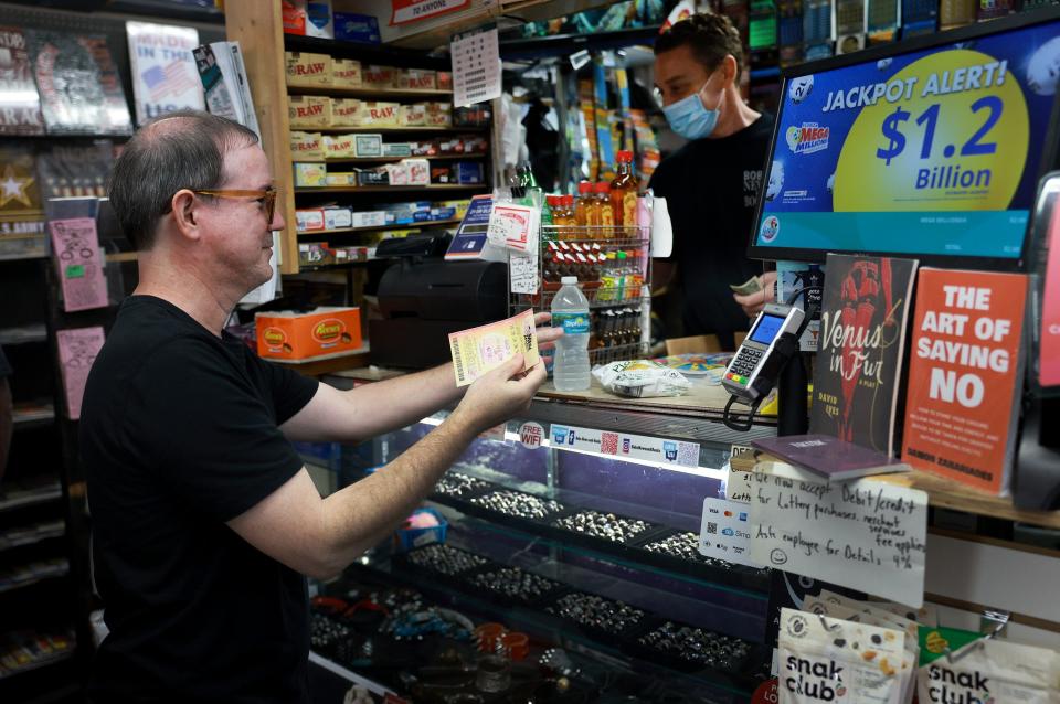 Erin Steinberg sells a Mega Millions lottery ticket to Anthony Bermude at his Bob's News u0026 Books store on Aug. 4, 2023, in Fort Lauderdale, Fla.