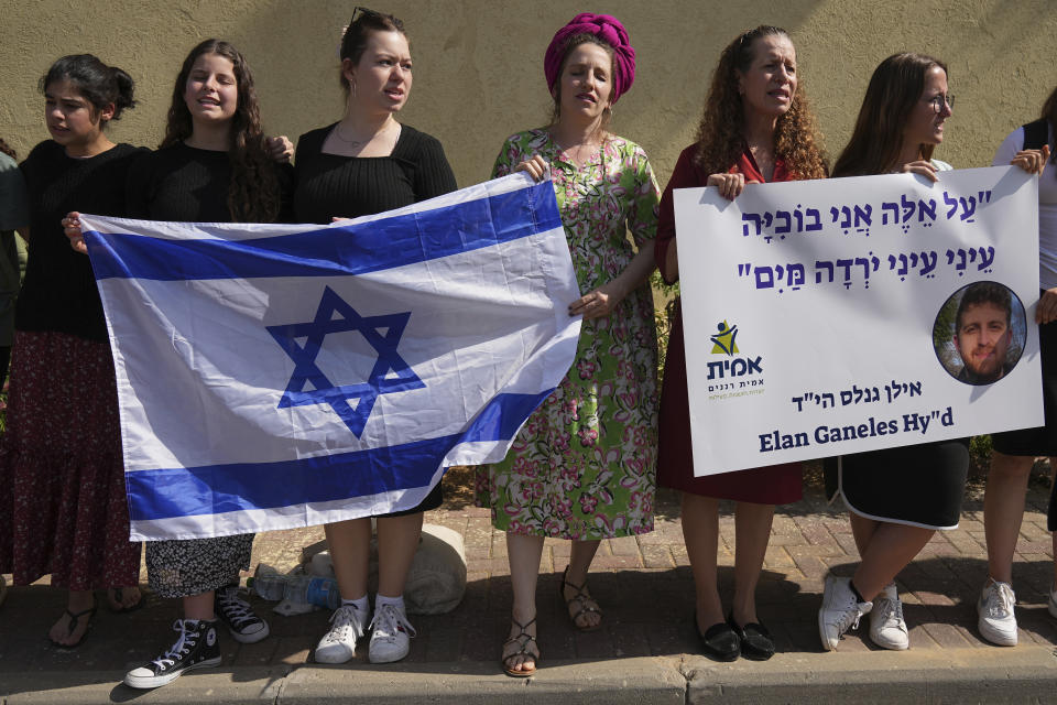 People line the street outside of the funeral of Elan Ganeles, 27, a dual U.S.-Israeli citizen from West Hartford, Connecticut, in Raanana, Israel, Wednesday, March 1, 2023. The Israeli army said a suspected Palestinian gunman opened fire on Tuesday at an Israeli car near the Palestinian city of Jericho, hitting Ganeles. A friend told local media he had been visiting Israel for a wedding and driving on a highway near the Dead Sea when he was shot. Hebrew reads: I Cry for these - my eyes, my eyes, the water came down." (AP Photo/Tsafrir Abayov)