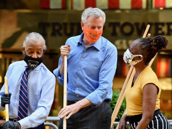 The Reverend Al Sharpton, New York Mayor Bill de Blasio and his wife Chirlane McCray, paint a new Black Lives Matter mural outside of Trump Tower (AFP via Getty Images)