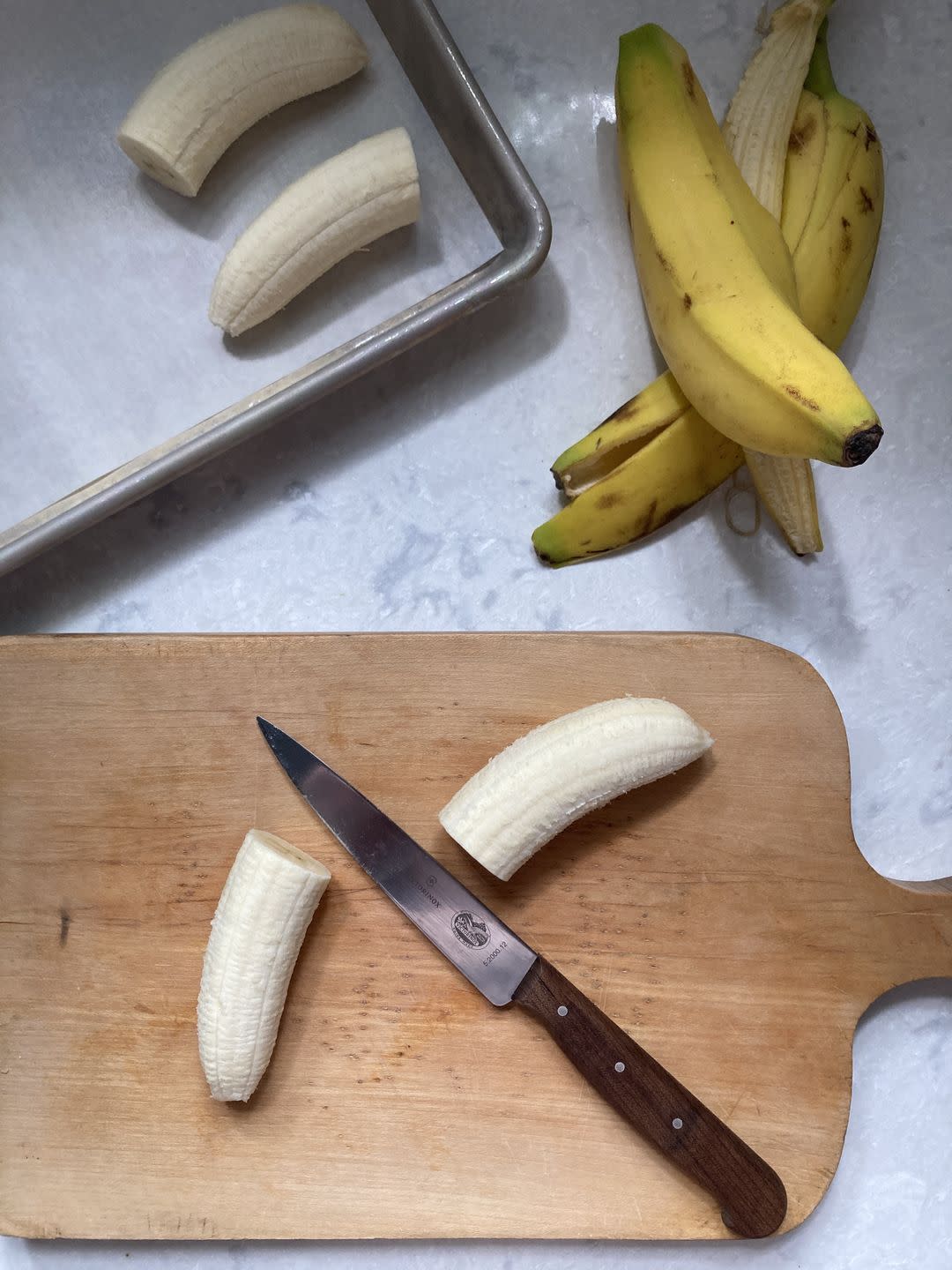 a knife and a cutting board with bananas on it