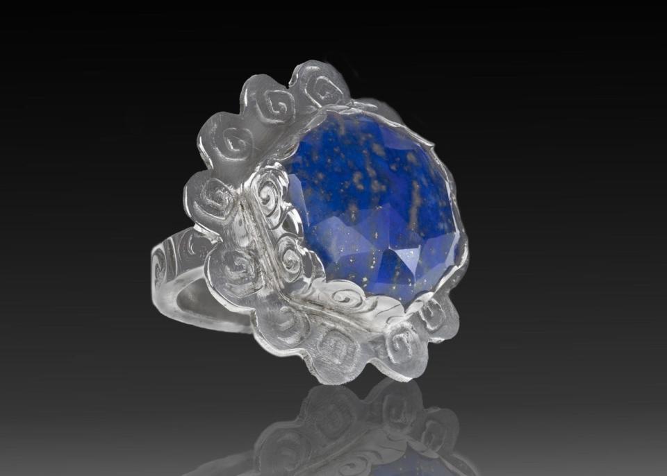 A ring handmade by Mary Lou Christie encases a blue speckled stone called lapis lazuli.