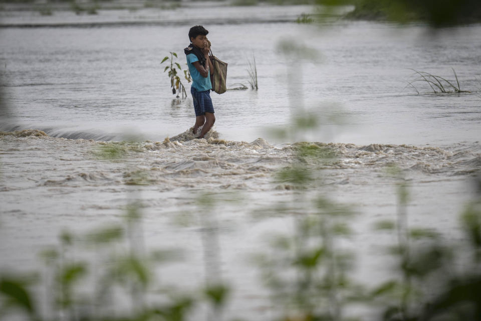 A boy wades through floodwaters in Bali village, west of Guwahati, India, Friday, June 23, 2023. Tens of thousands of people have moved to relief camps with one person swept to death by flood waters caused by heavy monsoon rains battering swathes of villages in India’s remote northeast this week, a government relief agency said on Friday. (AP Photo/Anupam Nath)