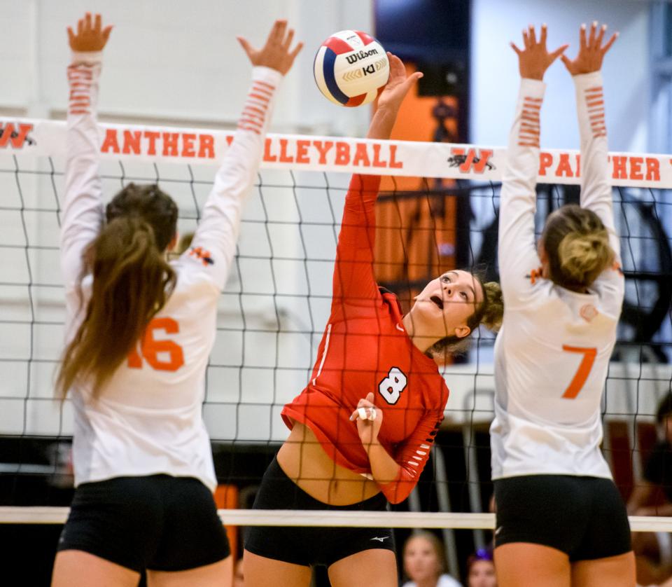 Metamora's Esma Frieden (8) spikes the ball between Washington's Sam Puent (16) and Grace Scrivner in the second set Tuesday, Sept. 6, 2022 in Washington. The Redbirds defeated the Panthers in straight sets, 25-12 and 25-18.