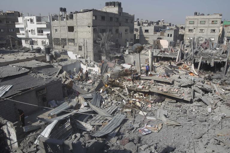 Palestinians inspect the wreckage of a building which was destroyed by an Israeli strike on the southern Gaza city of Rafah, on August 2, 2014