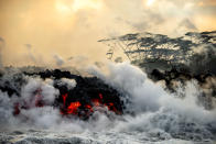 <p>Lava pours into surrounding waters, causing steam to rise. (Photo: CJ Kale/Caters News) </p>