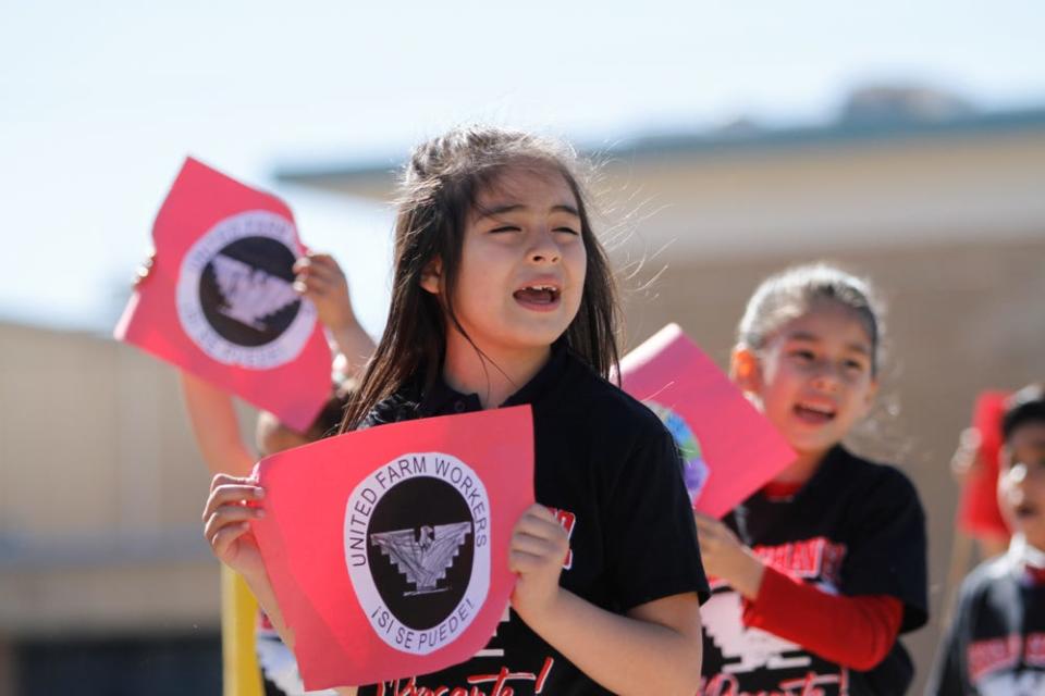 Pre-K to third-grade students from La Fe Preparatory School march through the Segundo Barrio in celebration of César Chávez Day on Friday. Students waved United Farm Workers flags and chanted, “Si se puede.”