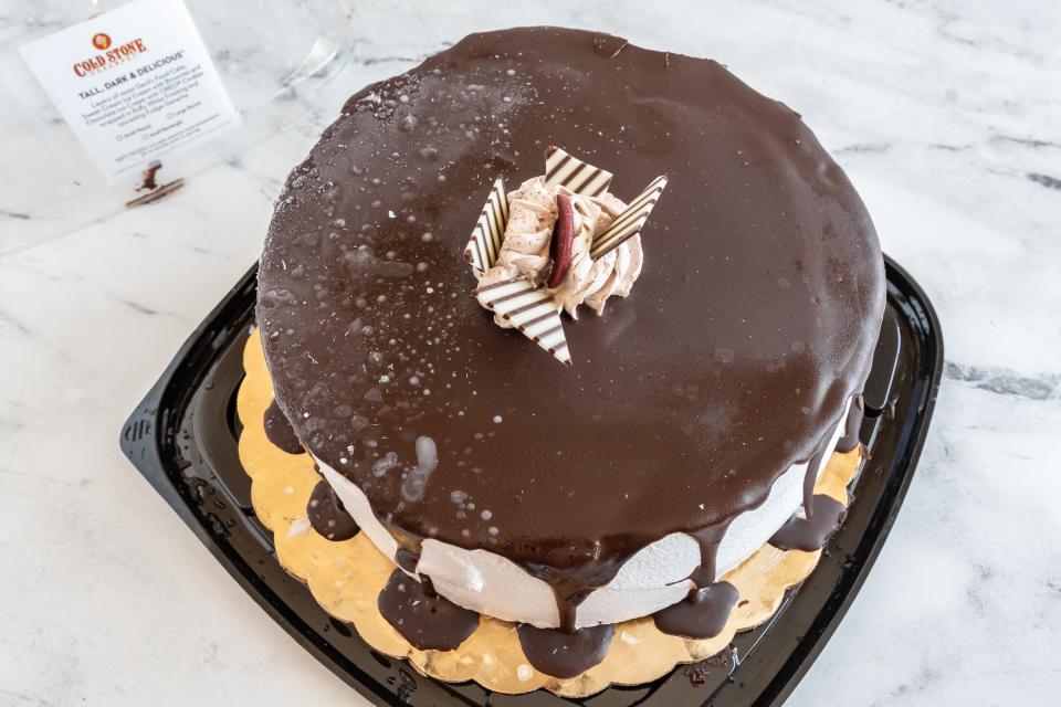 a cold stone creamery cake with chocolate drizzle on a white counter