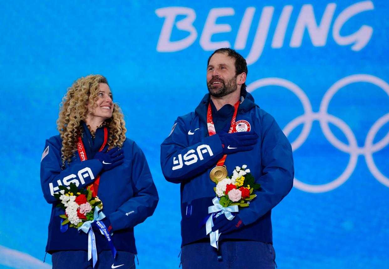 Feb 12, 2022; Zhangjiakou, CHINA; Lindsey Jacobellis and Nick Baumgartner (USA) celebrate their gold medal during the medals ceremony for the mixed team snowboardcross at the Beijing 2022 Olympic Winter Games at Zhangjiakou Medals Plaza.