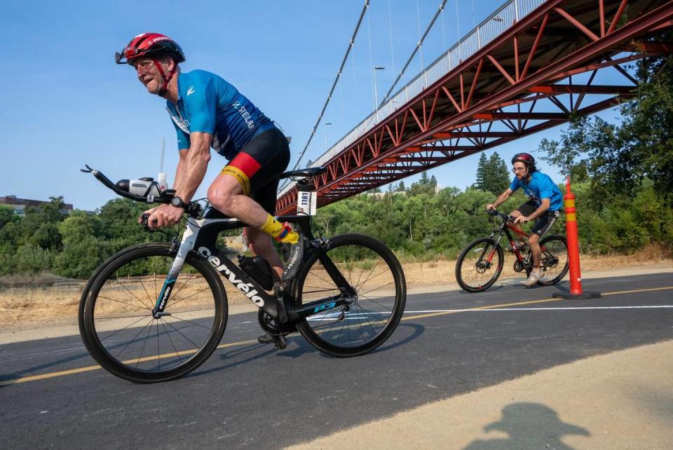 Top finisher Ben Lawry of Durham, N.C., left, takes off on the second leg of the Great American Triathlon near the Guy West Bridge on Saturday.