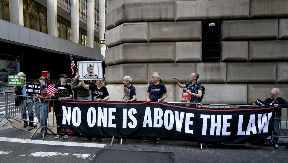 Protesters gather before former President Donald Trump arrives in a motorcade for a deposition in New York Thursday, April 13, 2023. (AP Photo/Craig Ruttle)