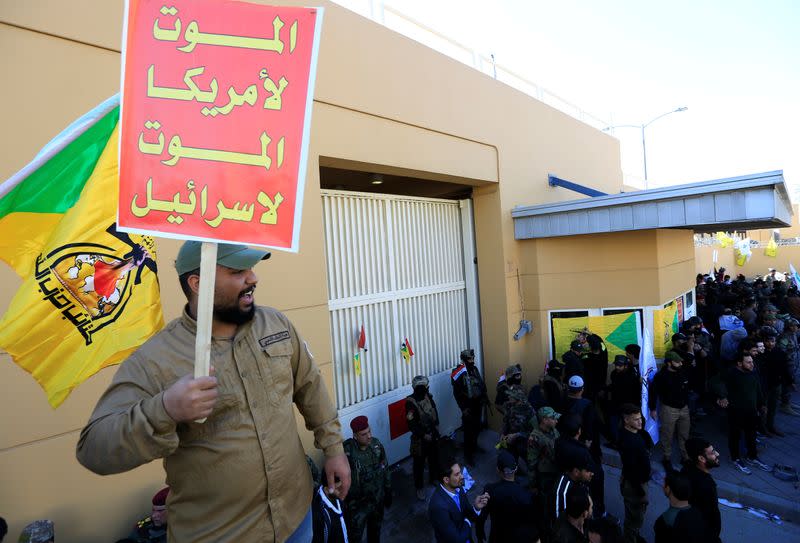 A Hashd al-Shaabi fighter holds a sign during a protest in Baghdad