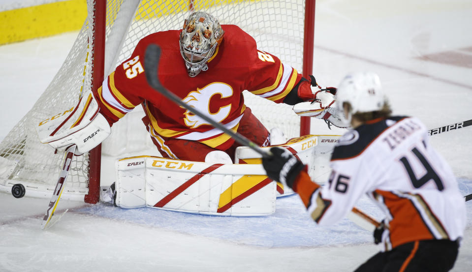 Anaheim Ducks' Trevor Zegras, right, has his shot blocked by Calgary Flames goalie Jacob Markstrom during the second period of an NHL hockey game in Calgary, Alberta, Monday, Oct. 18, 2021. (Jeff McIntosh /The Canadian Press via AP)
