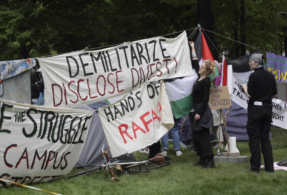 People arrange banners at a pro-Palestinians protest camp at the Vienna University Campus in Vienna, Austria, Tuesday, May 7, 2024. (AP Photo/Heinz-Peter Bader)