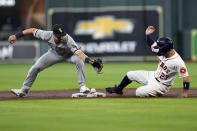 Houston Astros' Jose Altuve (27) slides safely into second base as Chicago White Sox second baseman Danny Mendick reaches for the throw from third baseman Yoan Moncada during the first inning of a baseball game Thursday, June 17, 2021, in Houston. Moncada was charged with a throwing error on the play. (AP Photo/David J. Phillip)