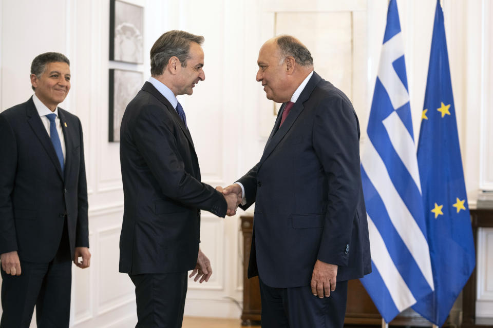 Greek prime minister Kyriakos Mitsotakis, center left, shakes hands with Egyptian Foreign Minister Sameh Shoukry,right, during their meeting in Athens, Tuesday, April 11, 2023. Greece and Egypt have close military ties and are planning to build an undersea electricity grid connector across the Mediterranean. (AP Photo/Petros Giannakouris)