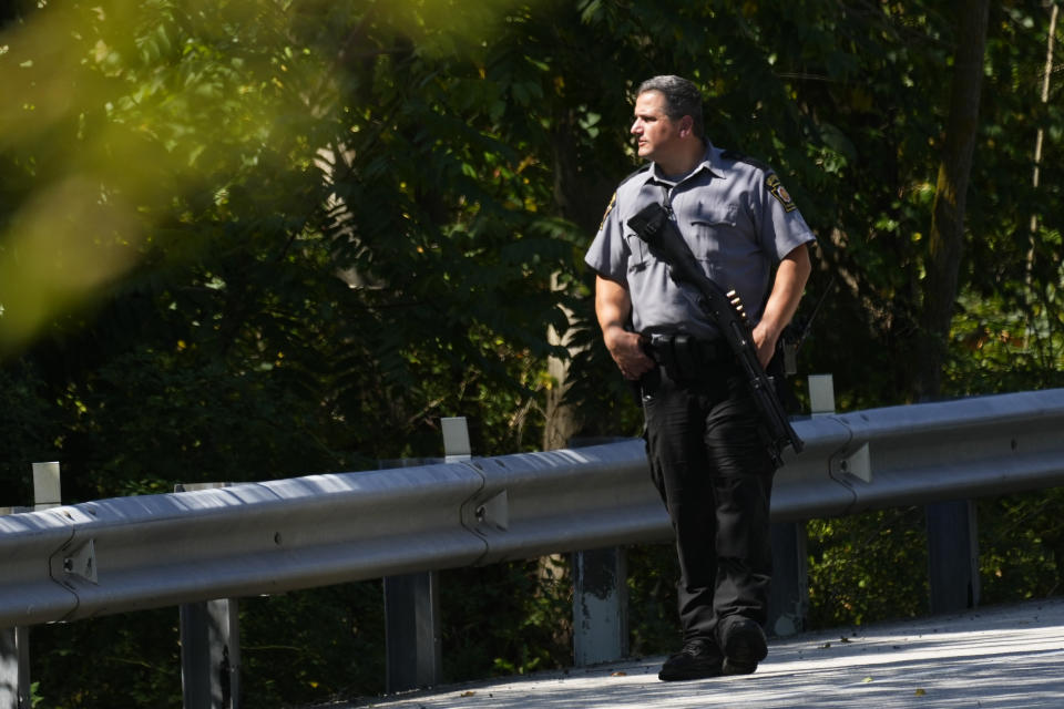 A law enforcement officer walks along the side of a road as the search for escaped convict Danelo Cavalcante continues in Pottstown, Pa., Tuesday, Sept. 12, 2023. (AP Photo/Matt Rourke)