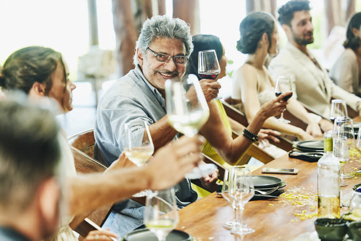 People around a table holding up wine glasses