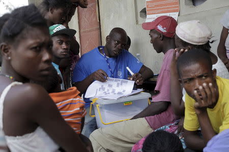 An enumerator with The International Organization for Migration (IOM) interviews people who returned from the Dominican Republic, at a camp for returned Haitians and Haitian-Dominicans, near the border between the Dominican Republic and Haiti, in Malpasse, August 3, 2015. REUTERS/Andres Martinez Casares