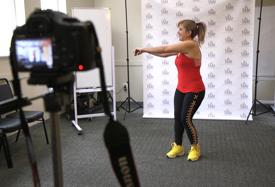 In this Tuesday, March 17, 2020 photo, dance instructor Lola Jaramillo records a Zumba and exercise lesson in Washington, that will be uploaded in the social media accounts of Vida Senior Center, a nonprofit that serves Washington’s older Hispanic community. (AP Photo/Federica Narancio)