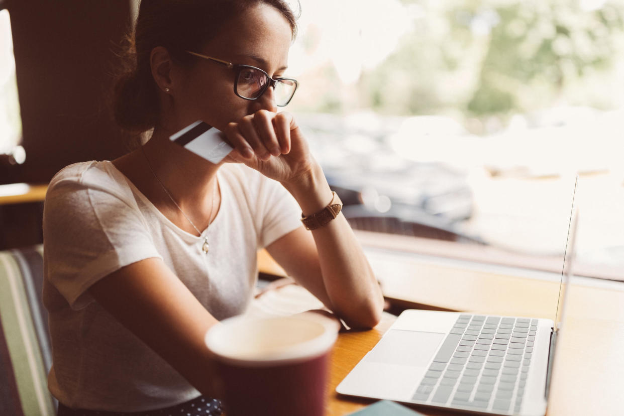 Getting an unsecured credit card with a below average credit score is possible, but read the fine print first. / Credit: Getty Images