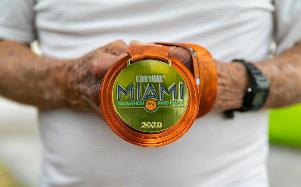 Lewis Ress, de 91 años, sostiene su medalla del Miami Marathon en el Don Soffer Exercise Trail en Aventura, Florida, el sábado 22 de enero de 2022. Ress, un antiguo abogado litigante que sigue trabajando y participando en la comunidad del sur de la Florida, competirá en la parte de medio maratón del Miami Marathon el 6 de febrero de 2022.