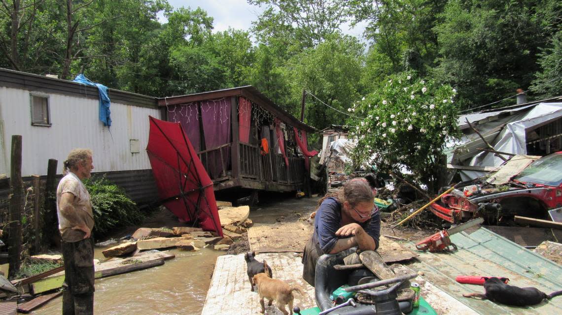 Joe Salley Jr., left, and Kayla Brown worked on a lawnmower amid the debris of their mobile home wrecked by a flood in the Grapevine community of Perry County on July 28, 2022. Brown fell during the flood while trying to escape and clung to a tree until she was rescued.