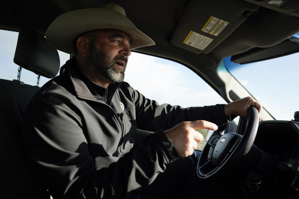 Terrell County Sheriff Thaddeus Cleveland drives to Bone Water Crossing on the Rio Grande River, Thursday, March 21, 2024, in Terrell County, Texas. (AP Photo/Erik Verduzco)