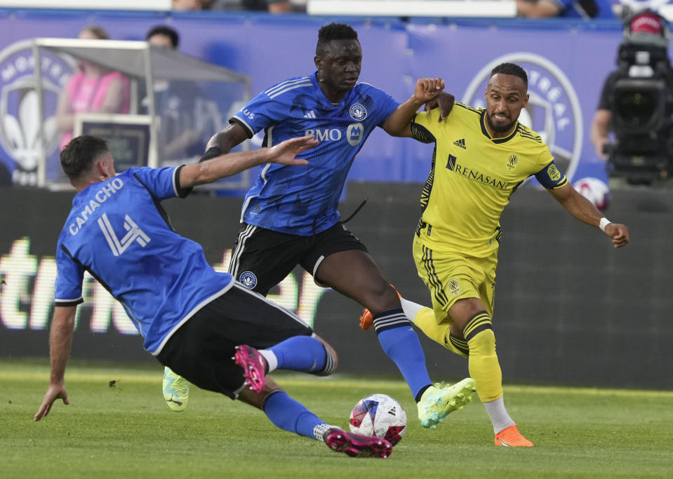 CF Montreal defender Rudy Camacho (4) and midfielder Victor Wanyama (2) defend against Nashville SC midfielder Hany Mukhtar, right, during the first half of an MLS soccer match Wednesday, June 21, 2023, in Montreal. (Christinne Muschi/The Canadian Press via AP)