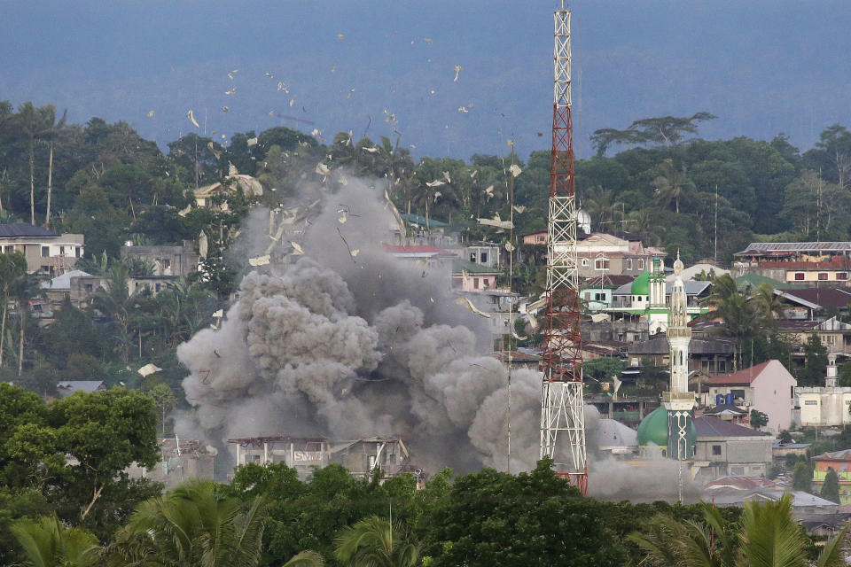 FILE - In this June 9, 2017, file photo, debris flies in the air as Philippine Air Force fighter jets bomb suspected locations of Muslim militants as fighting continues in Marawi city, southern Philippines. Philippine President Rodrigo Duterte decided to end martial law in the southern Philippines after more than two years after government forces weakened Islamic militant groups considerably with the capture and killing of their leaders, his spokesman said Tuesday, Dec. 10, 2019. (AP Photo/Aaron Favila, File)