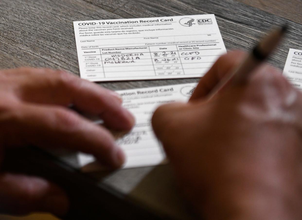 Lefty Barrera fills out a COVID-19 vaccine card, Thursday, Aug. 26, 2021. The program originally started with the elderly, but has expanded over time to all eligible for the vaccine. 