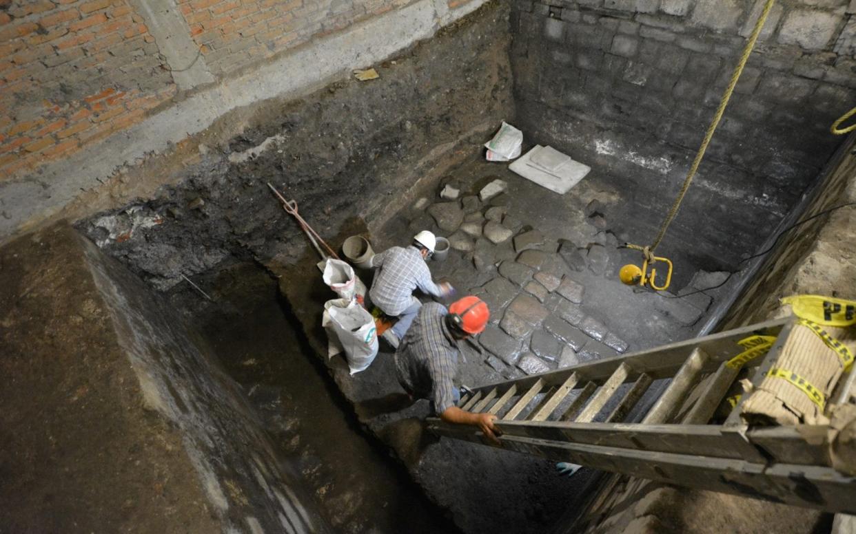 Archaeologists work on slabs of basalt belonging to vestiges of a pre-Hispanic palace -  INAH via REUTERS