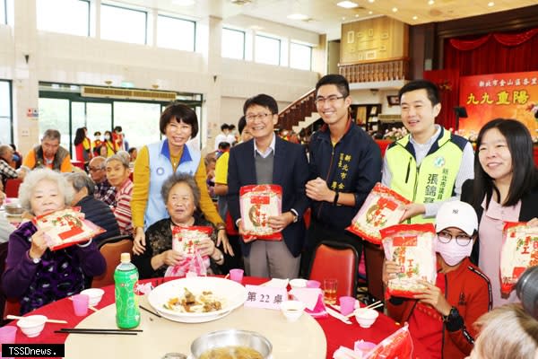 金山重陽敬老餐會連續十九年舉辦送麵線壽桃祝賀，新北市副市長陳純敬（後左二）參加金山重陽敬老餐會致贈長輩手工麵線。（圖：新北社會局提供）