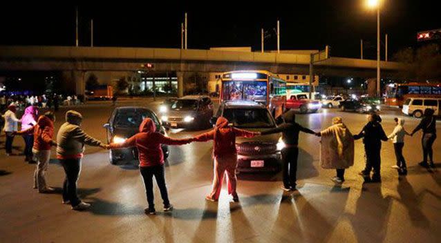 Family gathered around the prison where authorites have confirmed at least 52 inmates have been killed. Source: Reuters.