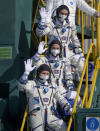 In this image provided by NASA, Russian cosmonaut Pyotr Dubrov, top, NASA astronaut Mark Vande Hei, middle, and Russian cosmonaut Oleg Novitskiy wave farewell prior to boarding the Soyuz MS-18 spacecraft for launch, Friday, April 9, 2021, at the Baikonur Cosmodrome in Kazakhstan. The astronaut and cosmonauts are scheduled to launch aboard the Soyuz MS-18 spacecraft Friday, to rendezvous with the International Space Station.(Bill Ingalls/NASA via AP)