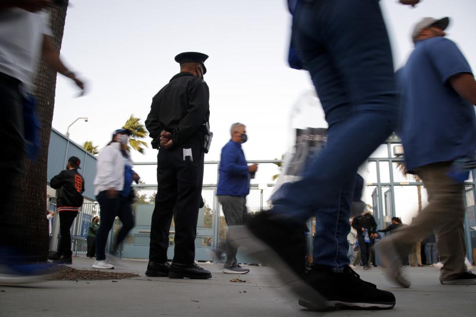 LAPD officer watch as fans walk through concourse.