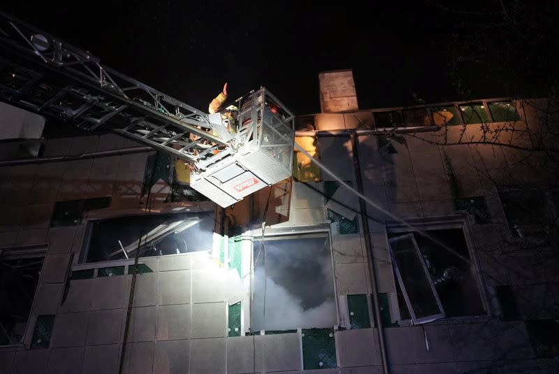 Rescuers work at the site where a building was damaged in the night by Russian drone strikes in Kyiv